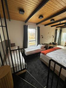 a bedroom with two beds and a window at Amma Jóna rooms in Ásólfsskáli