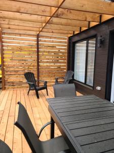 a patio with a table and chairs and a wooden wall at Dahlia #1 - Spa & Pets in Valcartier Station
