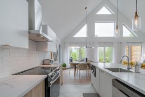 a kitchen with white appliances and a dining room at Dahlia #1 - Spa & Pets in Valcartier Station +47 photos