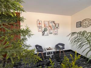 two chairs and a table in a room with plants at Peace The Green Heaven in Jaipur