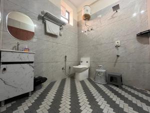a bathroom with a toilet and a sink and a mirror at Peace The Green Heaven in Jaipur +41 photos