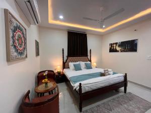 a bedroom with a bed and a table and a chair at Peace The Green Heaven in Jaipur
