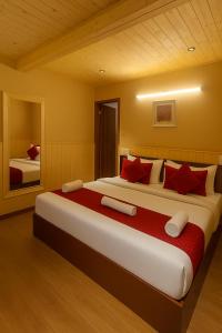 a bedroom with a large bed with red pillows at New Armadale Nainital in Nainital