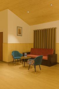 a room with a couch and a table and chairs at New Armadale Nainital in Nainital +32 photos