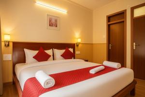 a bedroom with a large bed with red and white pillows at New Armadale Nainital in Nainital