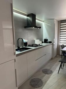 a kitchen with white cabinets and a stove at Casa in centrul Chisinaului in Chişinău