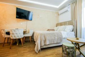 a bedroom with a bed and a table and a dining room at Panorama V Lux Vrnjačka Banja in Vrnjačka Banja