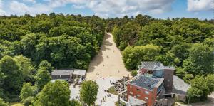 an overhead view of a long beach with a building and trees at Kust Geluk in Schoorl