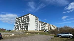 a white building with a car parked in front of it at Appartementhaus Ostseeresidenz in Heiligenhafen