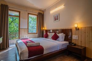 a bedroom with a large bed with red pillows at New Armadale Nainital in Nainital
