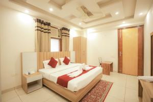 a bedroom with a large bed with red pillows at Hotel AR Residency in New Delhi +10 photos
