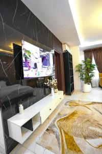 a living room with a flat screen tv on a wall at Clarence House in Ikeja