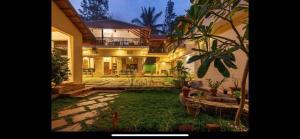 a house with a yard with plants in front of it at Airyaman Hollistic Hive in Narasimharaja Puram