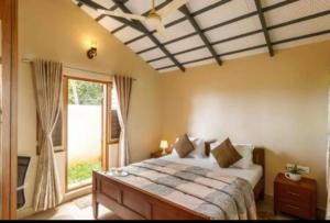 a bedroom with a large bed and a window at Airyaman Hollistic Hive in Narasimharaja Puram +52 photos