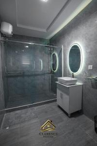 a bathroom with a shower and a sink and mirror at Clarence House in Ikeja +32 photos
