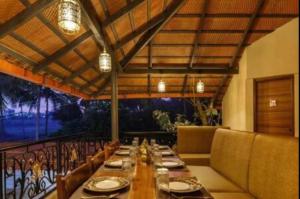 a long dining room with a long table and chairs at Airyaman Hollistic Hive in Narasimharaja Puram