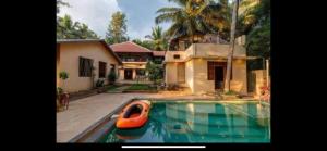 a house with a boat in a swimming pool at Airyaman Hollistic Hive in Narasimharaja Puram