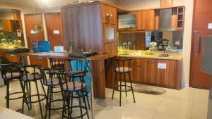 a kitchen with a bar with stools in it at Ancol Mansion Apartment Sea View by Berlin Village in Jakarta