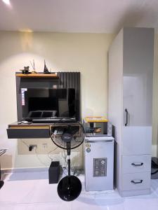 a room with a desk with a microwave and a refrigerator at Studio apartment in Surulere in Lagos