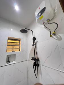 a room with a hair dryer on a white marble floor at Studio apartment in Surulere in Lagos +3 photos