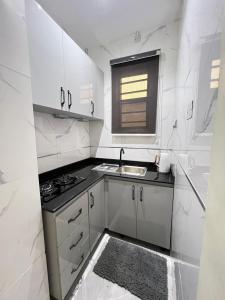 a white kitchen with a sink and a stove at Studio apartment in Surulere in Lagos