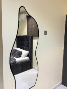a mirror on a wall with a couch in it at Studio apartment in Surulere in Lagos