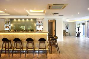 a bar in a hotel with stools around it at Athens Avenue Hotel in Athens
