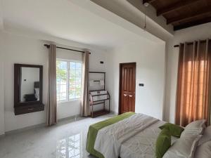 ein weißes Schlafzimmer mit Bett und Spiegel in der Unterkunft Star Gate in Nuwara Eliya