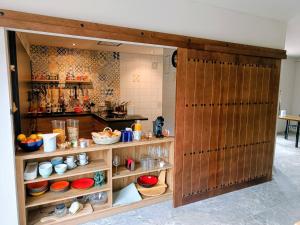 a kitchen with wooden doors and shelves with food at Casa la Perla Solo adultos in Béznar
