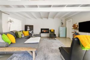 a living room with a couch and a fireplace at Charming B&B in Somerset West