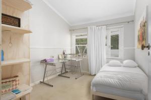 a bedroom with a bed and a desk in it at Charming B&B in Somerset West