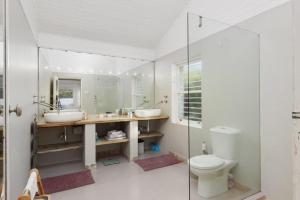 a bathroom with two sinks and a toilet at Charming B&B in Somerset West +17 photos