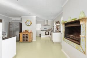 a large kitchen with a fireplace in the middle of it at Charming B&B in Somerset West
