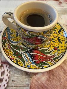 a cup of coffee on a plate on a table at Vila Rhea in Caciulata