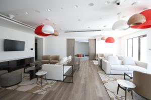 a living room with white furniture and red lamps at Premium Studio in Yas Golf Collection in Abu Dhabi