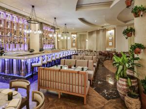 a restaurant with a bar and tables and chairs at SLS at Baha Mar in Nassau