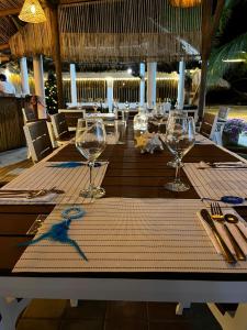 a wooden table with wine glasses on top of it at Boutique Playa DanRay in La Perdiz