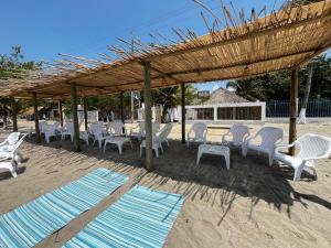 a group of chairs and tables on the beach at Boutique Playa DanRay in La Perdiz