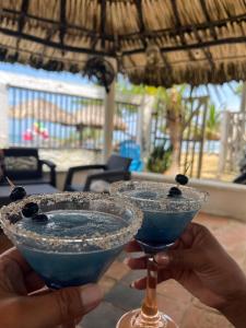 a person holding two martini glasses with a blue drink at Boutique Playa DanRay in La Perdiz +20 photos