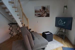 a living room with a couch and a staircase at Ludwig9 in Bayreuth