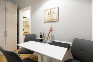 ein Esszimmer mit einem weißen Tisch und Stühlen in der Unterkunft Vienna Midtown Apartment in Wien