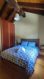 a bedroom with a bed with a blue and white comforter at Villa Quijada in Trefacio