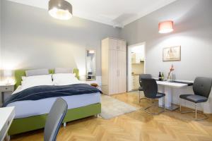 ein Schlafzimmer mit einem Bett und einem Schreibtisch und Stühlen in der Unterkunft Vienna Midtown Apartment in Wien