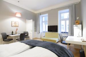 ein Hotelzimmer mit einem Bett, einem Schreibtisch und Stühlen in der Unterkunft Vienna Midtown Apartment in Wien
