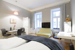 ウィーンにあるVienna Midtown Apartmentのベッド、デスク、椅子が備わるホテルルームです。