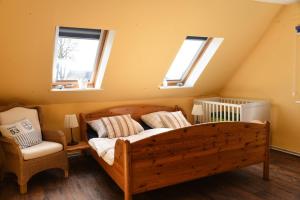 a bedroom with a wooden bed and two windows at Ferienwohnung Ankerpladsen Opti in Behrensdorf