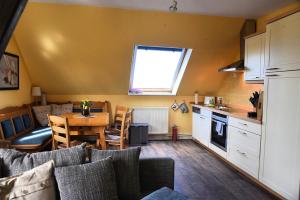 a kitchen and living room with a table and a kitchen and a dining room at Ferienwohnung Ankerpladsen Opti in Behrensdorf