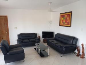 a living room with two couches and a tv at Caoba in Las Terrenas