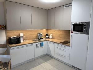 a kitchen with white cabinets and a white refrigerator at Vila 512 priamo pri jazere in Šajdíkove Humence