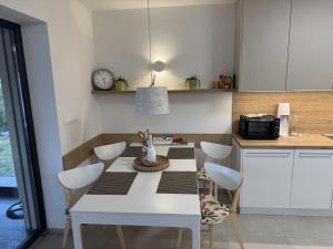 a kitchen with a table with chairs and a clock at Vila 512 priamo pri jazere in Šajdíkove Humence
